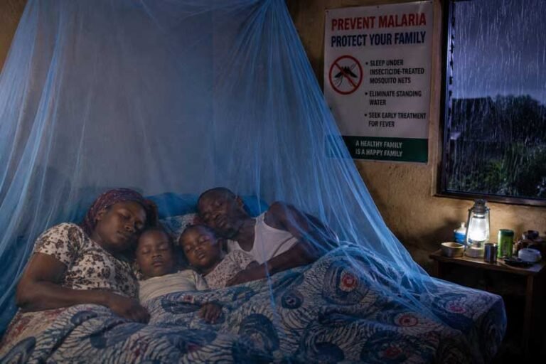 A realistic Nigerian family sleeping safely under insecticide-treated mosquito nets during rainy season